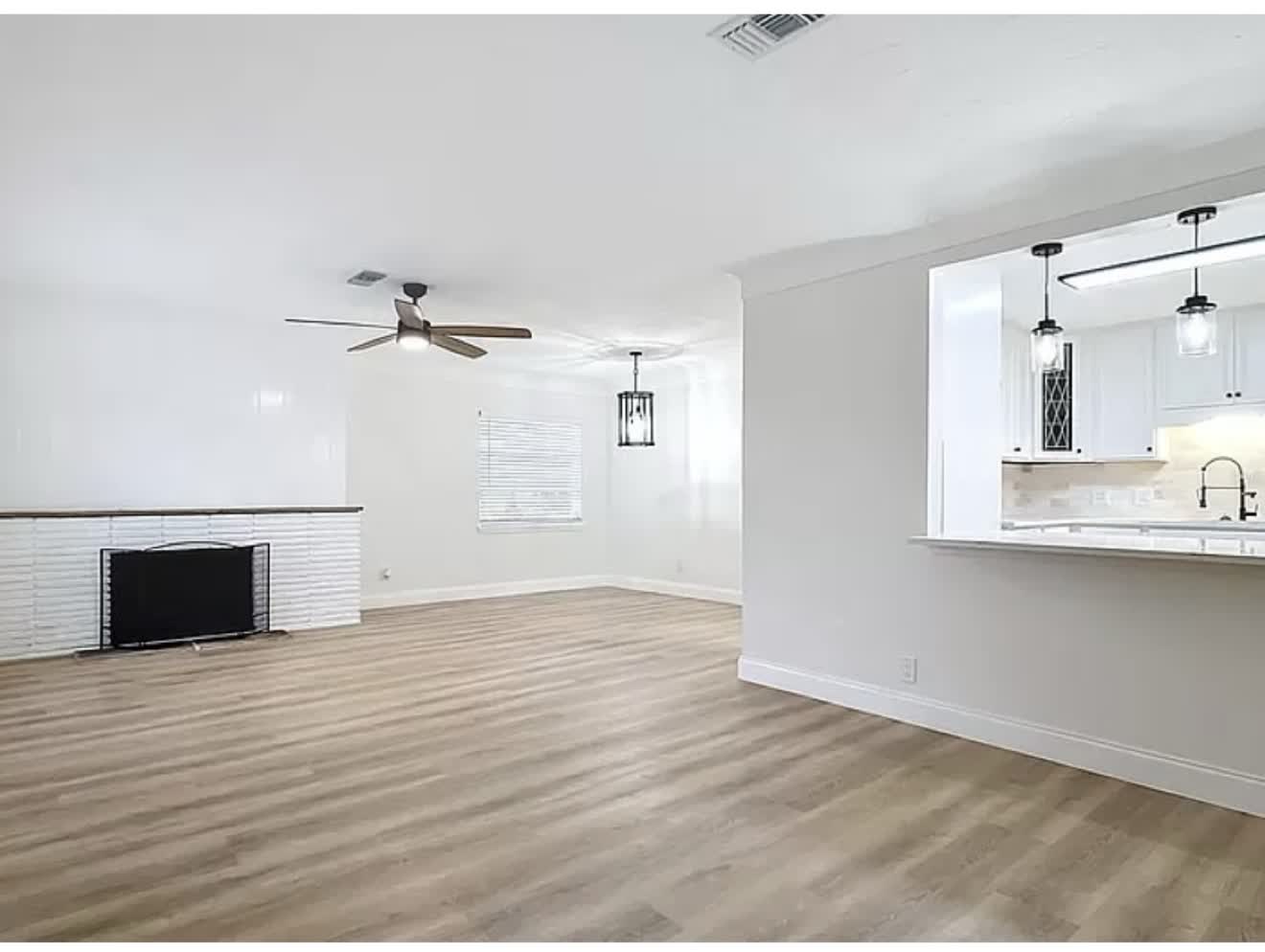 Remodeled living room with finished wood-look flooring and clean white trim