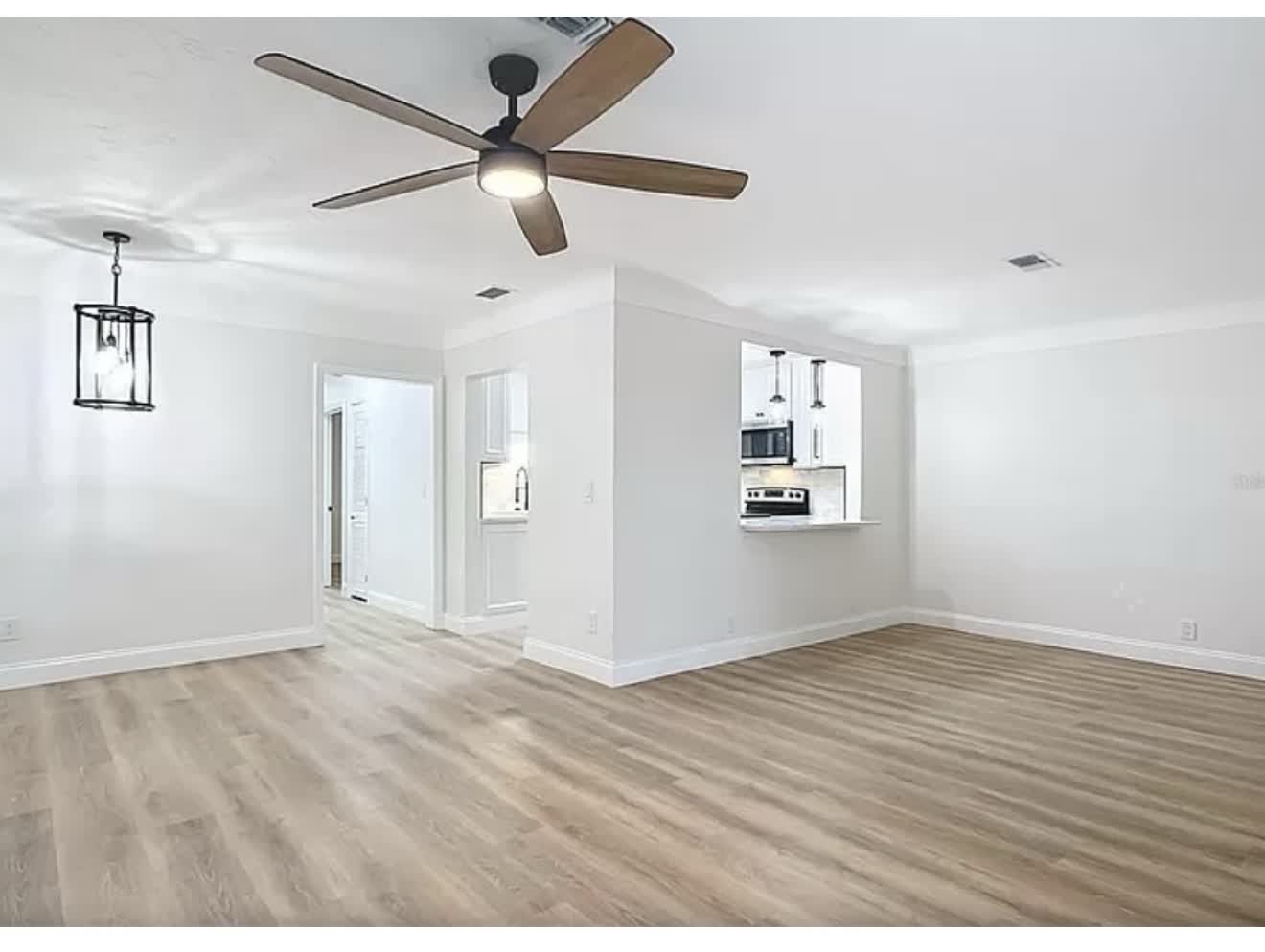 Remodeled living room with fireplace and wood-look flooring, second angle