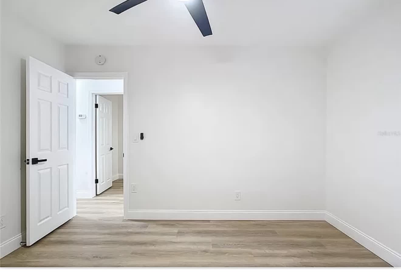 Remodeled bedroom with double closet doors and wood-look flooring, second angle