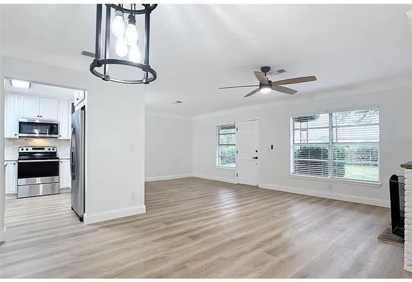 Open living area and remodeled kitchen with wood-look flooring, first angle
