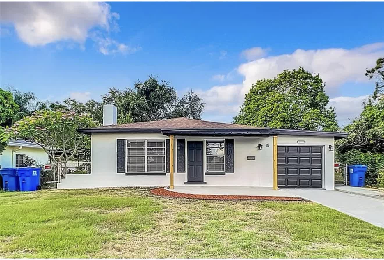 Remodeled house front exterior with white paint and black trim, second angle