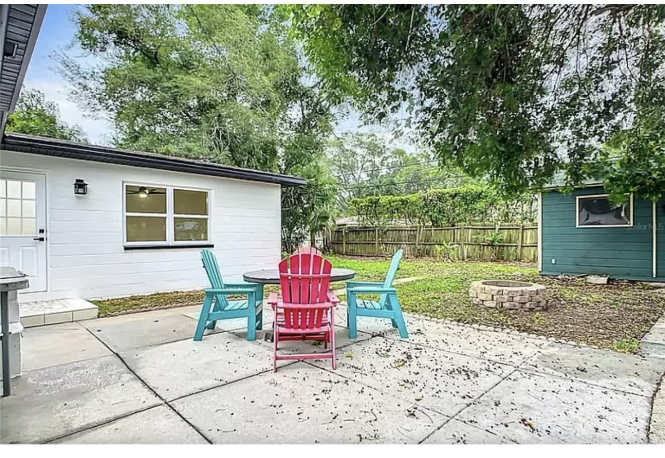 Remodeled backyard patio with colorful seating and clean concrete