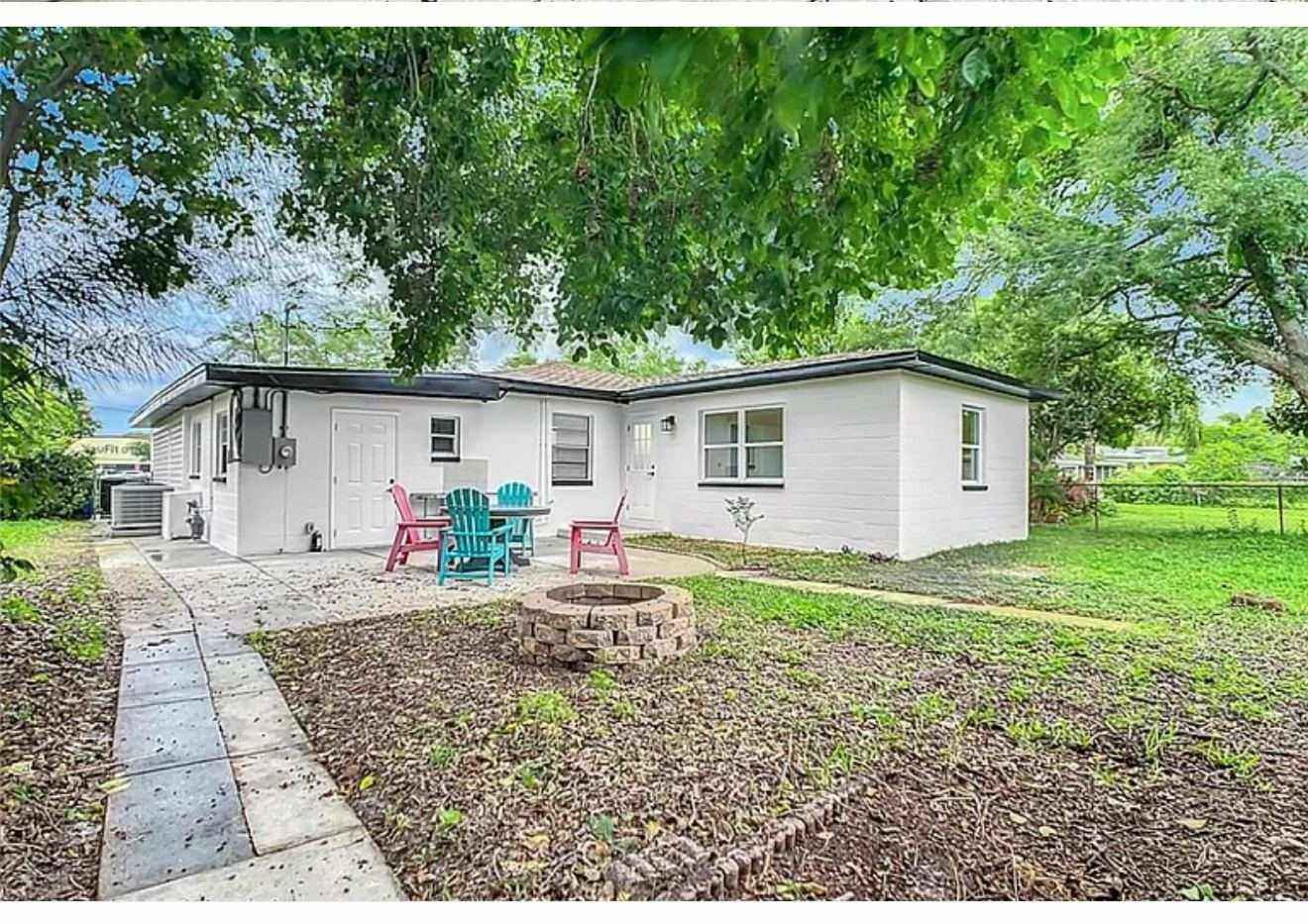 Backyard view of remodeled house with refreshed patio, landscaping, and painted exterior